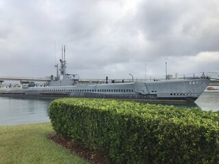 Ein historisches U-Boot im Hafen von Pearl Harbor, Hawaii, unter einem wolkigen Himmel.