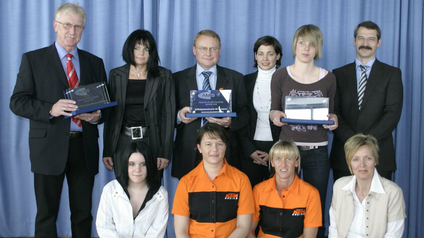 Gruppenfoto beim AMS Award Frauen in Technik, mit mehreren Teilnehmerinnen und Teilnehmern vor einer Bühne posierend.